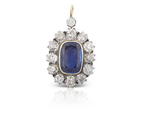 the rectangular cushion shaped sapphire in a yellow rubbed over setting, within a border of old cut diamonds, surmounted by a