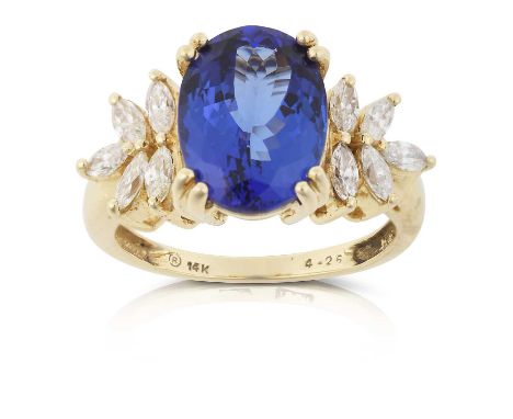 the oval cut tanzanite flanked by marquise cut diamonds, in yellow claw settings, to a tapered shoulder plain polished shank,