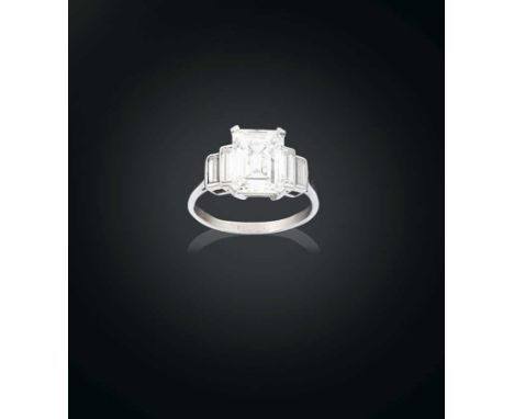 the central emerald-cut diamond flanked by graduated pairs of baguette cut diamonds, in white claw and rubbed over settings, 