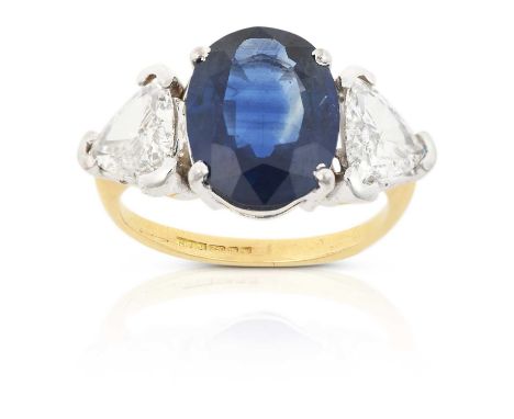 the oval cut sapphire flanked by trilliant cut diamonds, in white claw settings, to a yellow tapered shoulder plain polished 