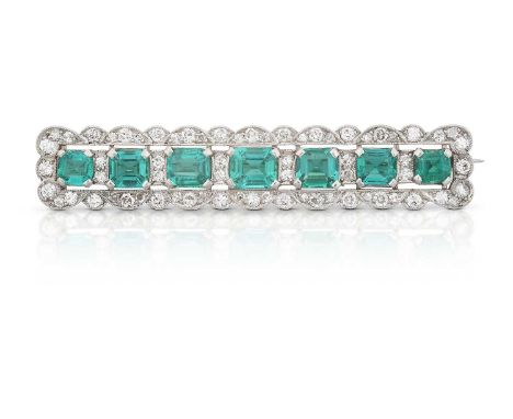 seven graduated emerald-cut emeralds spaced by pairs of round brilliant cut diamonds, within a scalloped border of round bril