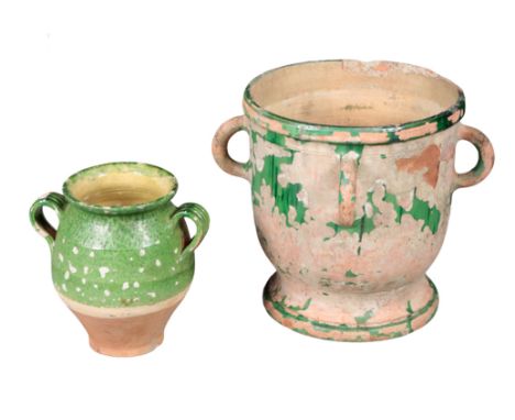 A TERRACOTTA AND GREEN-GLAZED PLANTER with four hooped handled to the sides, 44cm high x 42cm wide, together with another ter