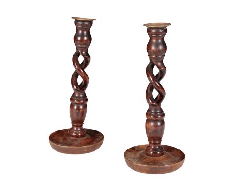 A PAIR OF OAK AND BRASS-MOUNTED CANDLESTICKS 19th century, with double helix carved stems, each 31.5cm high (2)Provenance: Th