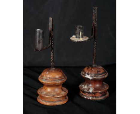 TWO RUSH LIGHT HOLDERS 19th century, both with wrought iron stems on turned fruitwood bases, the taller 28cm high, the other 