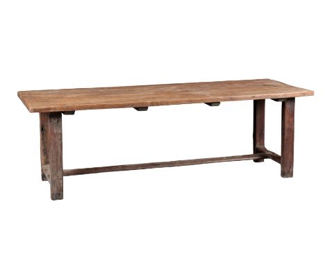 AN OAK FARMHOUSE REFECTORY TABLE early 19th century and later, the boarded top on block legs joined by stretchers, 71cm high 