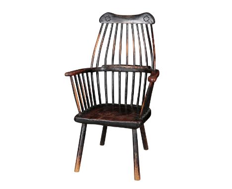 A PRIMITIVE ASH AND ELM WINDSOR ARMCHAIR, POSSIBLY IRISH early 19th century, the shaped and carved cresting rail over a parti