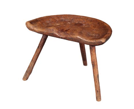 A PRIMITIVE ELM DAIRY STOOL early 19th century, with shaped seat, 35cm high x 46cm wide x 29cm deep Provenance: The Richard P