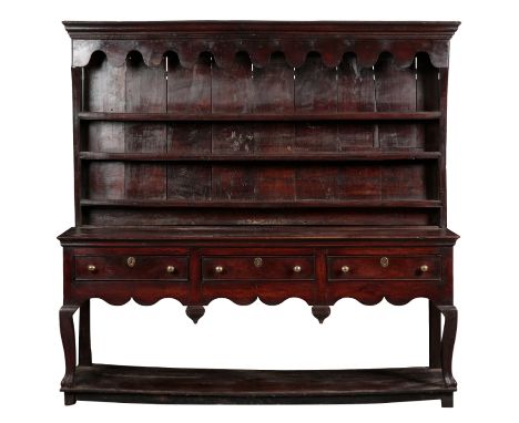 A PROVINCIAL OAK DRESSER 18th century and later, the plate rack with an undulating frieze, and iron hooks, on a base with thr