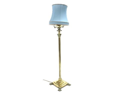 Early 20th century brass Corinthian column standard lamp, with shade, stepped base, and paw feet, converted from gas, H171cm 