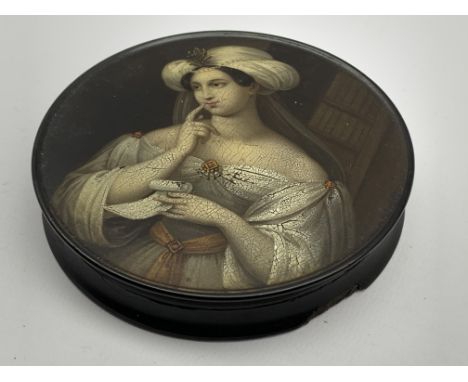 Early 19th Century Stobwasser papier mache circular snuff box the cover painted with a portrait of a Lady In a Turban holding