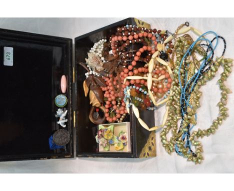 A Chinese style jewellery box having brass fitments and containing a selection of costume jewellery including beads and ceram