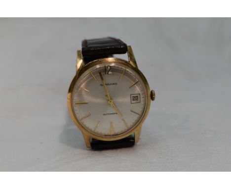 A gents 1970's yellow metal automatic wrist watch by Garrard having a baton numeral dial with date aperture in plain case wit