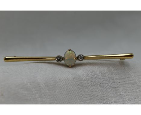 A 9ct gold bar brooch having a central opal flanked by two diamonds