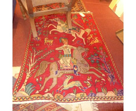 A Persian rug the red field having image of huntsmen on horseback and garden motifs