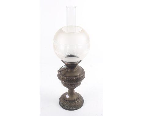 A Victorian oil lamp. The brass stand with embossed and pierced decoration, the later shade with etched floral decoration. H6