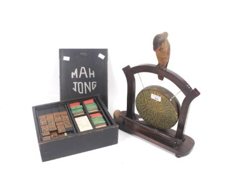 A vintage boxed Mahjong set and a brass gong on stand. The Mahjong set containing painted wooden chips, the gong stand topped