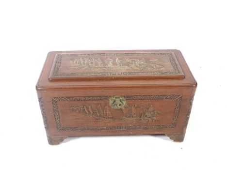 A contemporary Chinese campher wood trunk. The hinged lid opening to reveal a fitted interior, the top and sides heavily carv