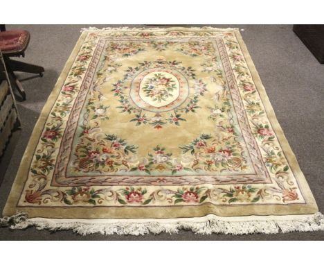 A large 20th century woollen woven rug. Featuring a large central medallion on a light brown base, surrounded by multiple pin