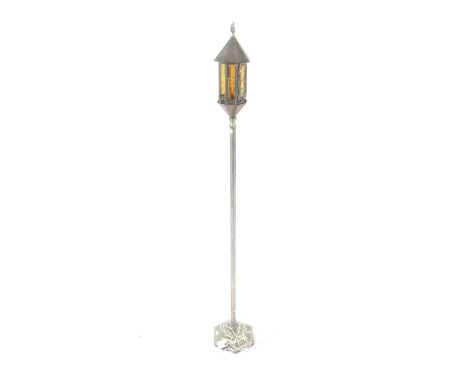 A 20th century brass standard lamp. Modelled as a lantern with orange and clear textured glass panels, mounted on a heavily e