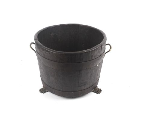 A 19th century wooden coopered planter or wine cooler. With two wrought iron straps, two brass handles and three brass claw f