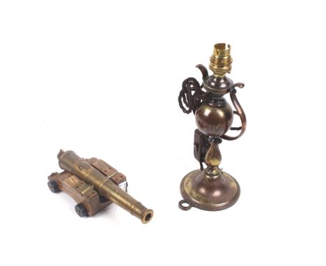 A vintage nautical style oil lamp on gimbal and a model cannon. The lamp H27cm, the brass cannon featuring a British crest in