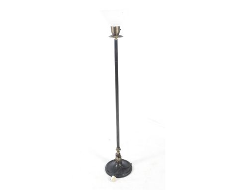 An early 20th century standard lamp. The cast metal structure painted black with brass details, topped with a pink glass shad