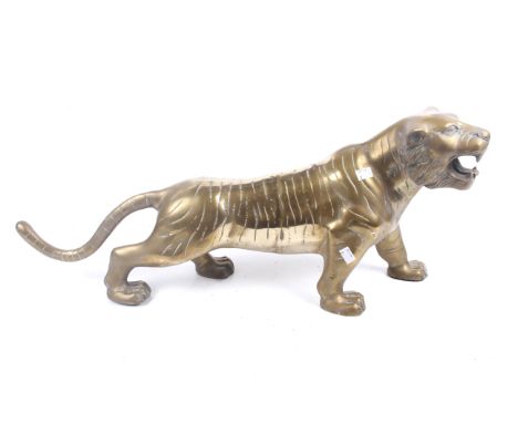 A large Japanese style weighted brass figure of a tiger. The animal in a hunting position, with engraved details, unsigned, M