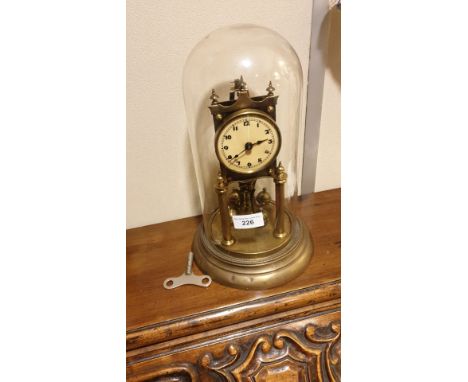 Large Victorian Glass Domed Brass Dome clock with revolving  pendulum  and key winds and revolving  stands 30 cms tall . 