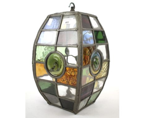 A lead and coloured glass lantern/lampshade. With suspension hook to top, the glass in shades of red, orange and green. H33cm