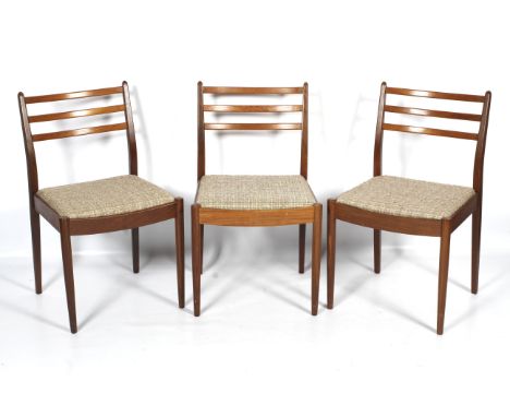 Three 1960s G-Plan teak chairs dining chairs. With curved ladder backs and upholstered drop-in seats, on tapering cylindrical