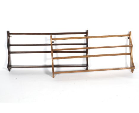 Two mid-century Ercol plate racks. In dark and light stains, each with two slotted shelves suspended between shaped uprights,