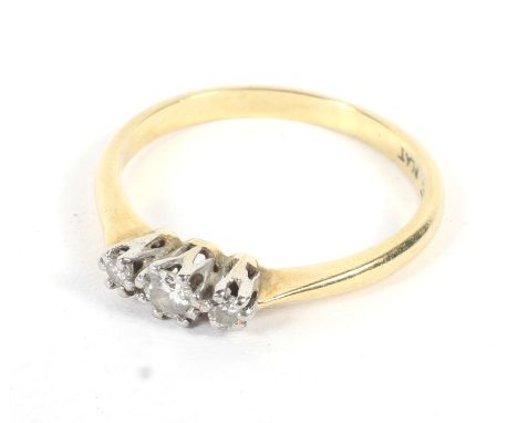 An 18ct gold and platinum set three stone diamond ring. Size R, weight 2.6 grams. 