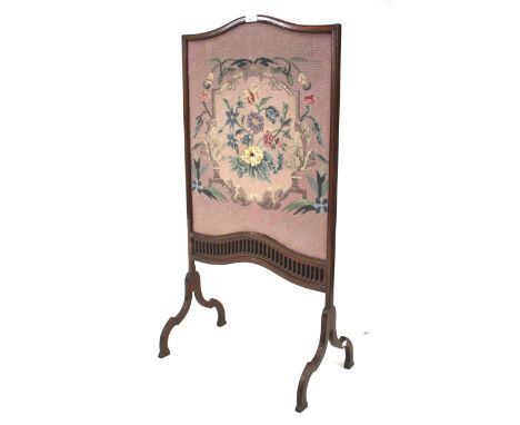 An Edwardian fire screen. The pierced mahogany frame featuring a tapestry panel of flowers on a pink ground. H106cm