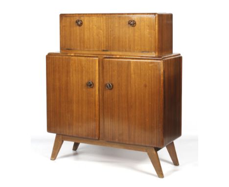 A 1960s Rivington veneered drinks cabinet. The hinged top section opening to reveal three mirrored surfaces, the double doors