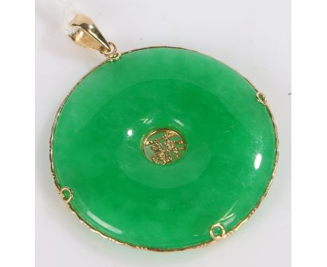 Chinese Jade disc, with 14k gold mount, centred with a character mark, 3cm diameter