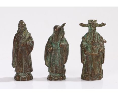 Three Oriental cast metal figures, to include figure holding a stick and orb, 8.5cm high (3)