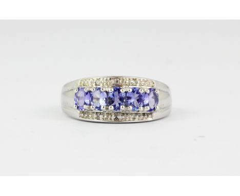 A 9ct white gold tanzanite and diamond set ring, (M).