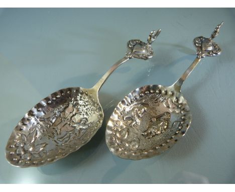 Pair of continental silver caddy spoons, with embossed figural decorations and cockerel terminal