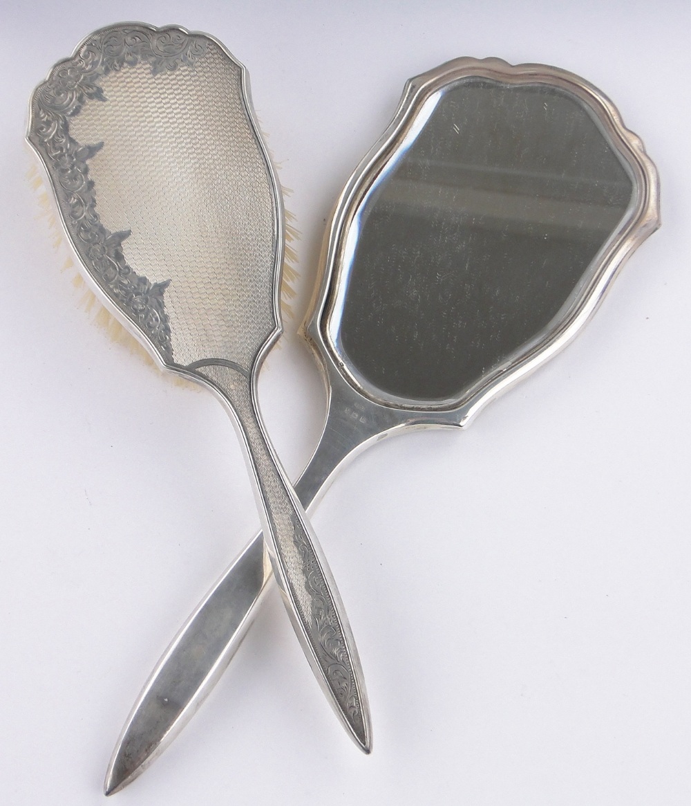 A 5piece engraved silver backed brush and mirror set,Birmingham 1957, original case.
