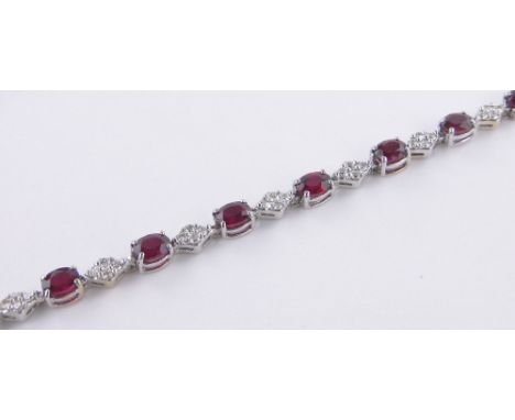 An 18ct white gold ruby and diamond set line bracelet,length 19cm.