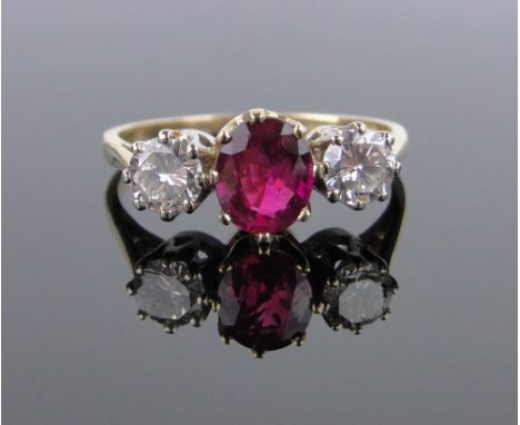 An 18ct gold 3 stone ruby and diamond ring,total diamond content approx. 0.7cts, ruby height 8mm, size R.