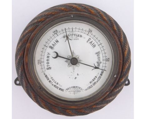 A Victorian carved oak cased aneroid wall barometer,with ropetwist surround, diameter 18cm.