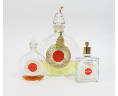 A vintage Guerlain, Paris 'Shalimar' eau de cologne shop fatice bottle, of flattened disc form, with tassel and applied paper