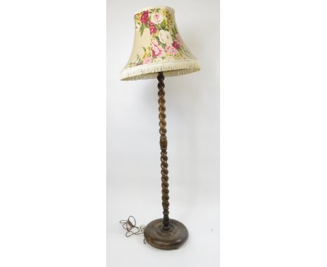A 20th century oak standard lamp with a barley twist stem and floral shade