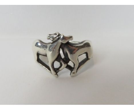 A silver ring, unmarked, designed with two confronting horses
