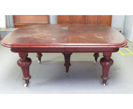 A Victorian mahogany dining table, with carved bulbous legs on ceramic casters, moulded border, 73cm high, 349cm long, 129cm 