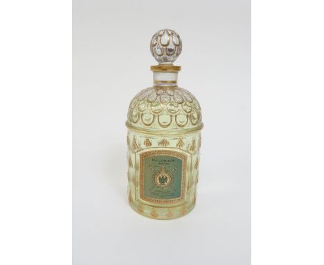 A vintage Guerlain shop fatice perfume bottle, of cylindrical form, with moulded bee motif framing a cartouche with applied p