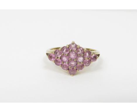 A 9 carat gold pink sapphire cluster ring, stamped '9K', set with sixteen round cut stones, finger size N, 2.4 g gross