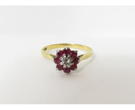 A diamond and ruby cluster ring, stamped 'Plat' and '18ct', the central brilliant cut of approximately 0.08 carats enclosed b