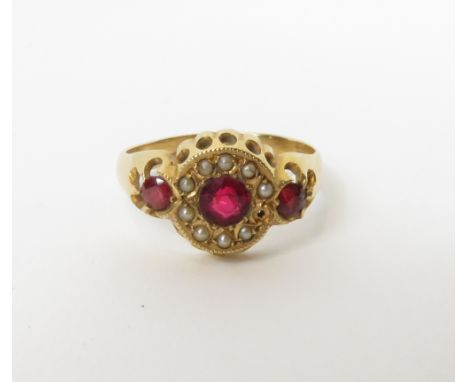 An 18 carat gold three stone red doublet ring, with simulated split pearl border, Birmingham 1919, finger size Q, 3.9 g gross